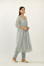 Blue hand block printed V neck gathered kurta set, highlighted with gota flower embroidery and scalloped organza at edges.