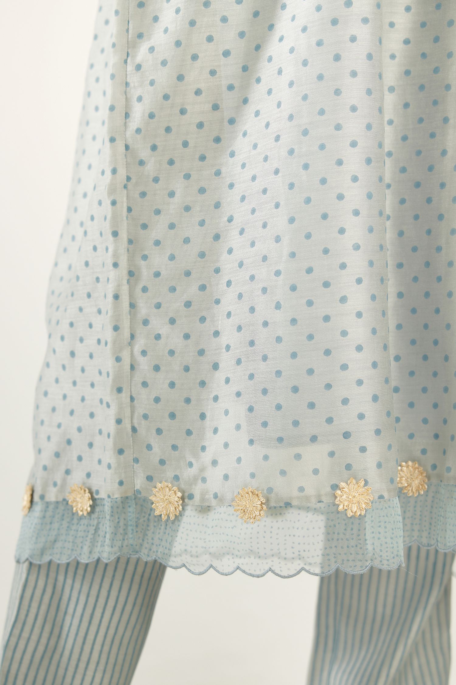 Blue hand block printed V neck gathered kurta set, highlighted with gota flower embroidery and scalloped organza at edges.