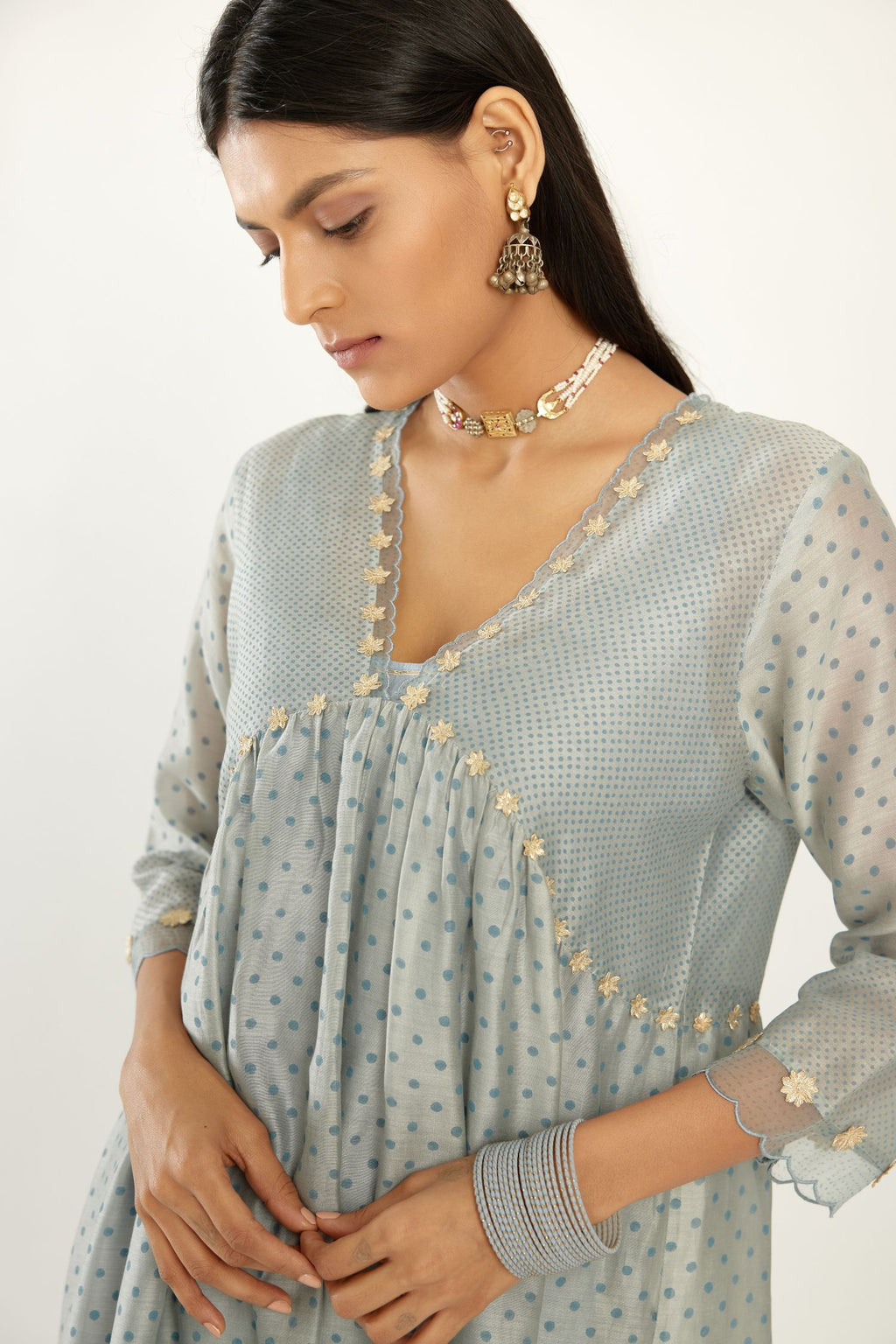 Blue hand block printed V neck gathered kurta set, highlighted with gota flower embroidery and scalloped organza at edges.