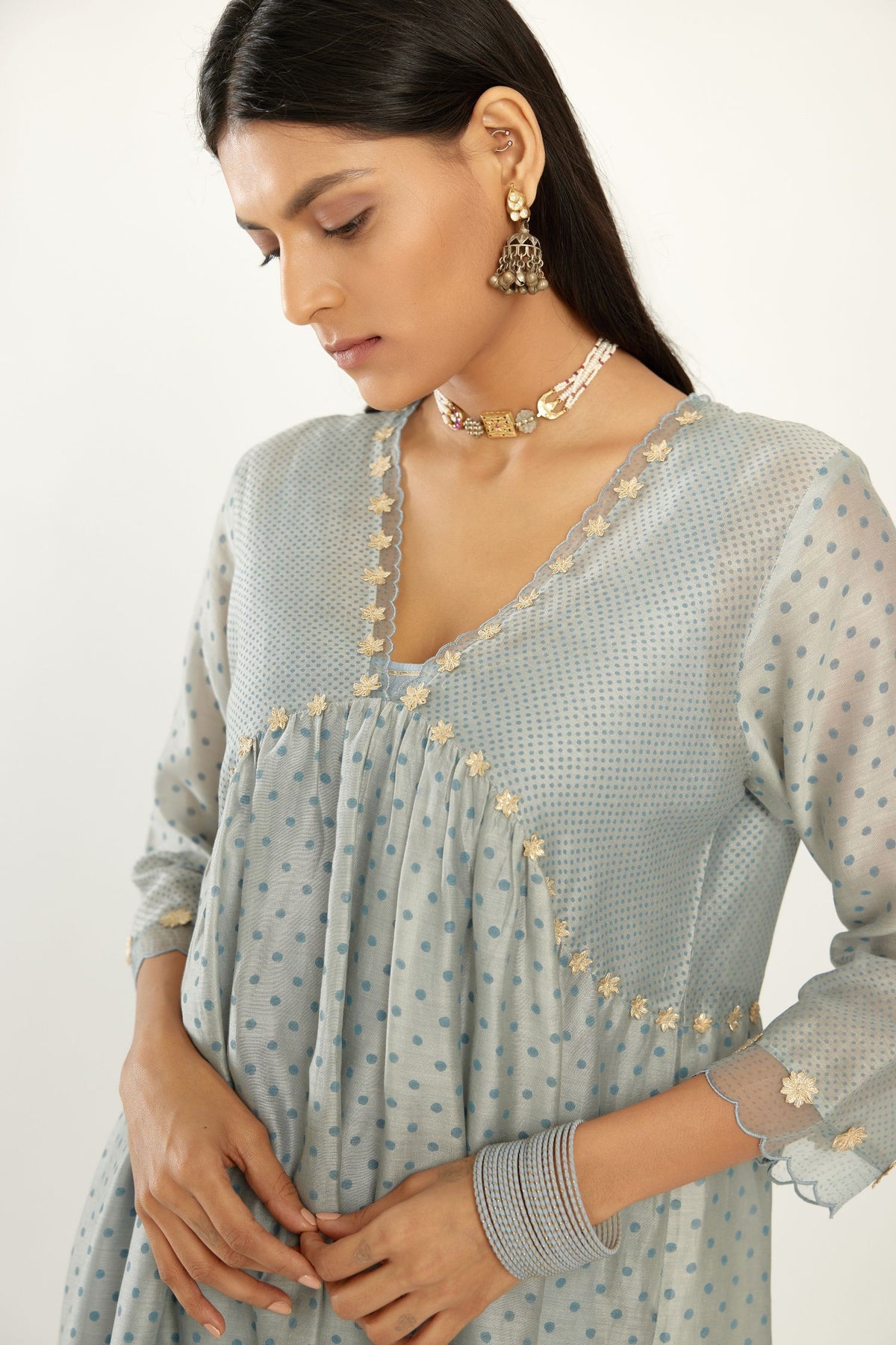Blue hand block printed V neck gathered kurta set, highlighted with gota flower embroidery and scalloped organza at edges.