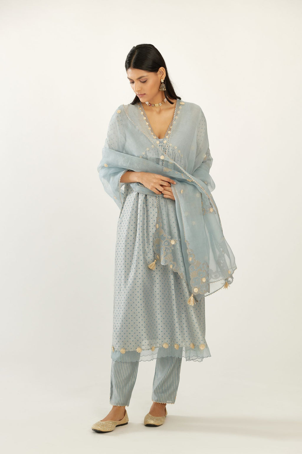 Blue hand block printed V neck gathered kurta set, highlighted with gota flower embroidery and scalloped organza at edges.