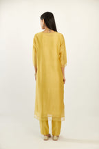 Yellow silk chanderi hand block printed straight kurta set, highlighted with scalloped organza at edges.