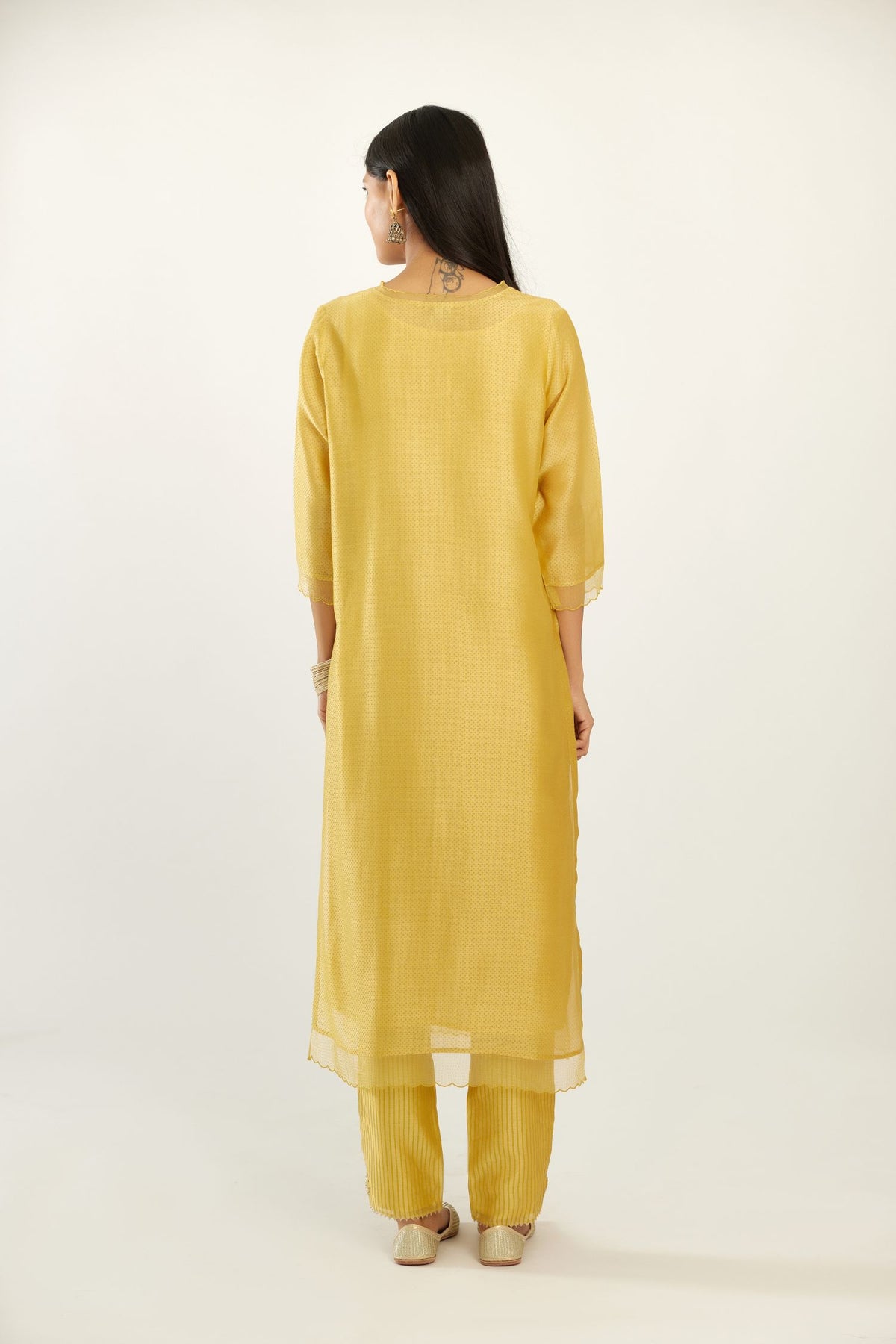 Yellow silk chanderi hand block printed straight kurta set, highlighted with scalloped organza at edges.