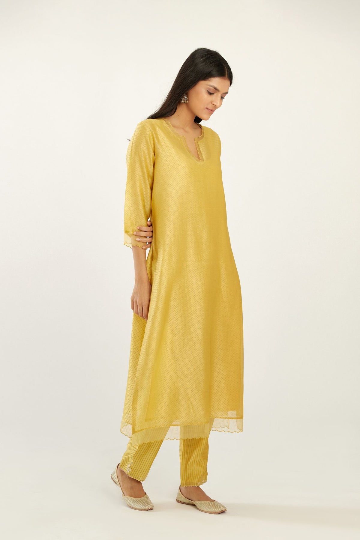 Yellow silk chanderi hand block printed straight kurta set, highlighted with scalloped organza at edges.