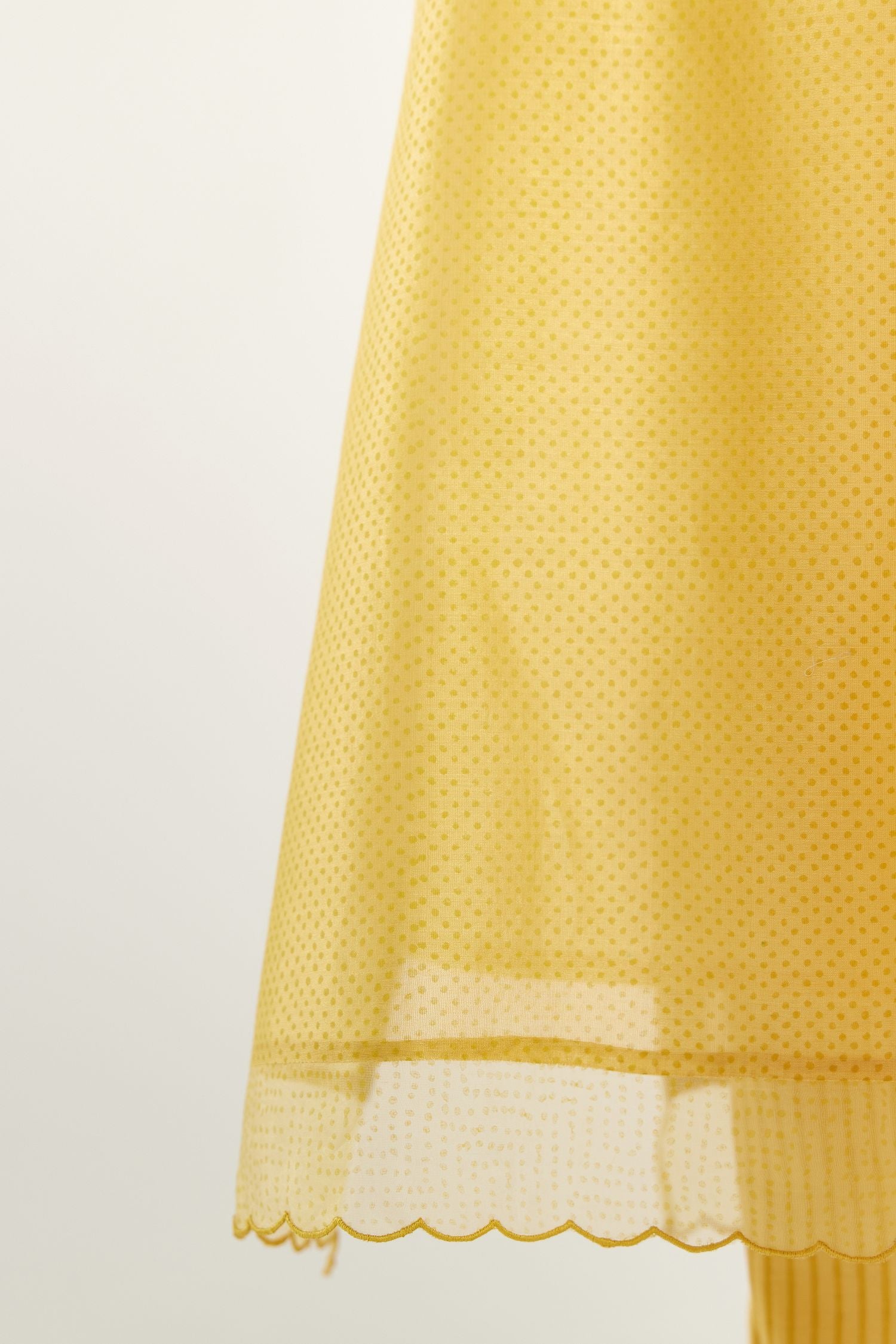 Yellow silk chanderi hand block printed straight kurta set, highlighted with scalloped organza at edges.