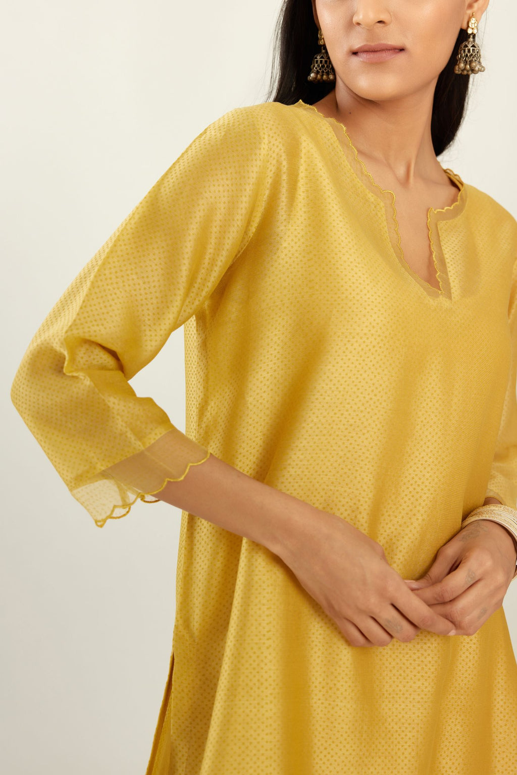 Yellow silk chanderi hand block printed straight kurta set, highlighted with scalloped organza at edges.