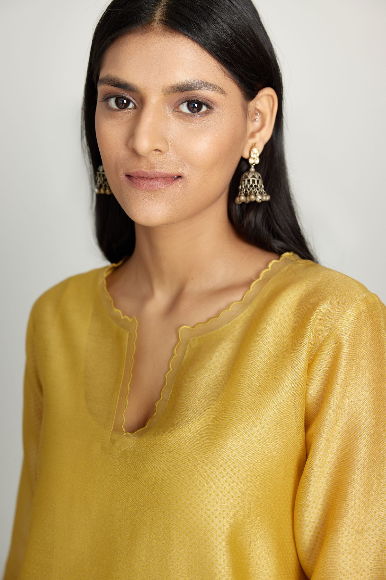 Yellow silk chanderi hand block printed straight kurta set, highlighted with scalloped organza at edges.