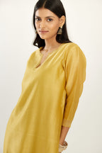 Yellow silk chanderi hand block printed straight kurta set, highlighted with scalloped organza at edges.
