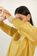 Yellow silk chanderi hand block printed straight kurta set, highlighted with scalloped organza at edges.