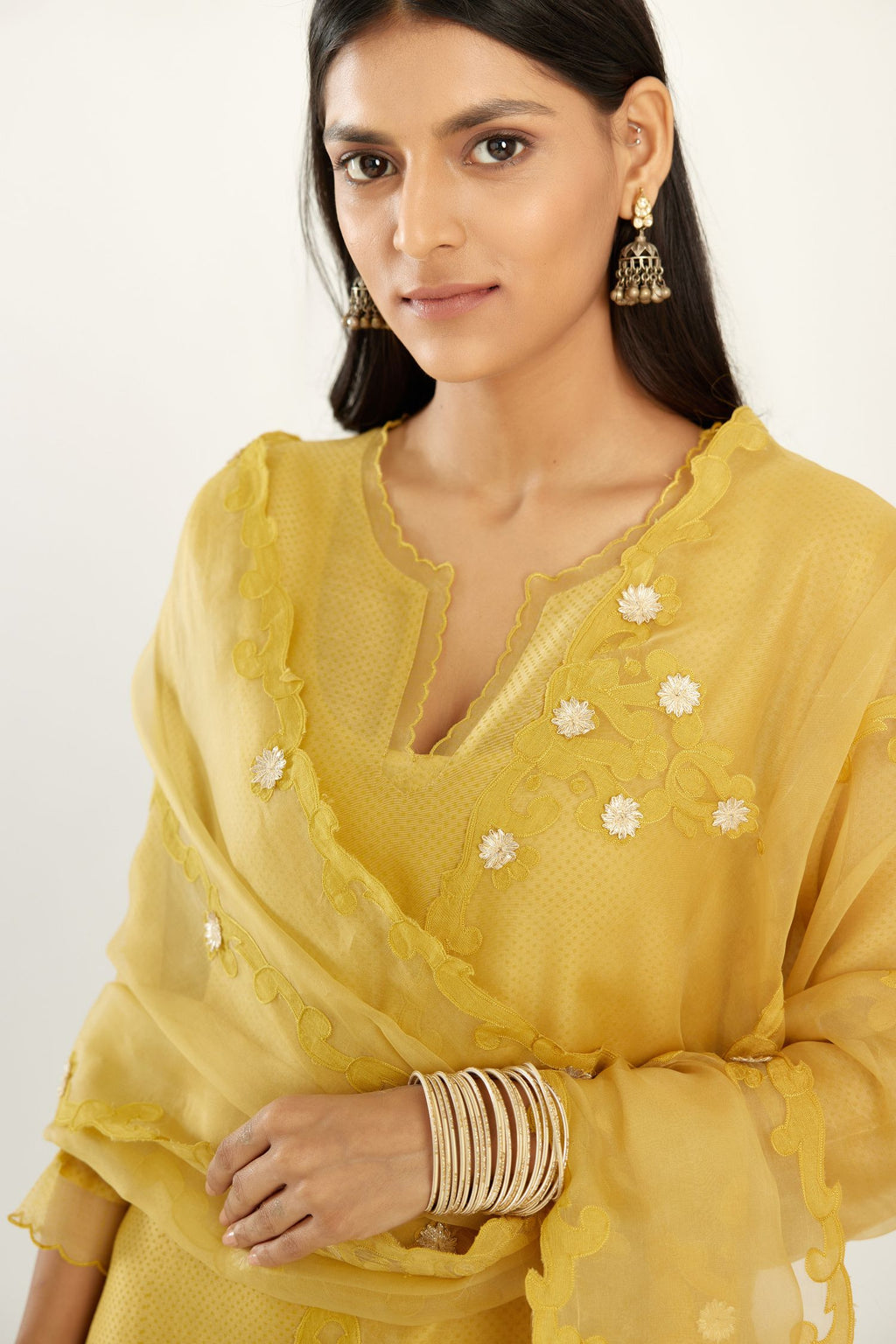 Yellow silk chanderi hand block printed straight kurta set, highlighted with scalloped organza at edges.