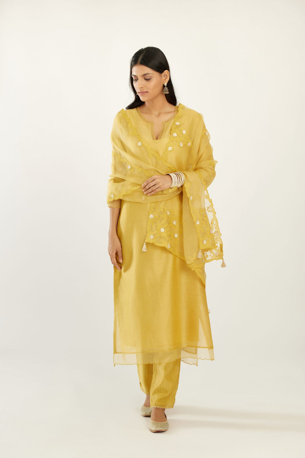 Yellow silk chanderi hand block printed straight kurta set, highlighted with scalloped organza at edges.