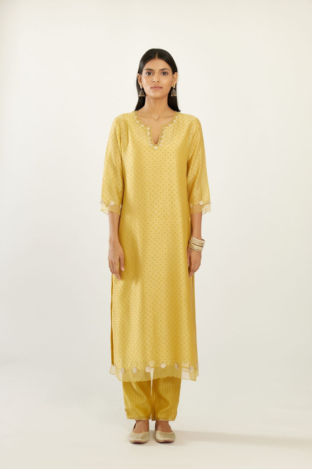 Yellow silk chanderi hand block printed straight kurta set, highlighted with organza and gota embroidered flower at edges.
