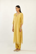Yellow silk chanderi hand block printed straight kurta set, highlighted with organza and gota embroidered flower at edges.