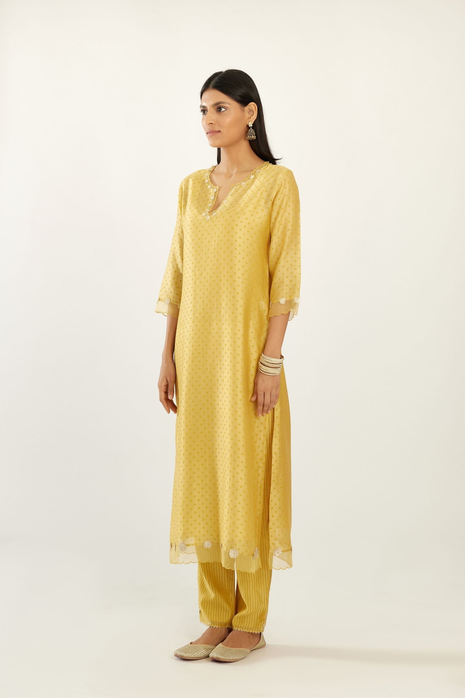 Yellow silk chanderi hand block printed straight kurta set, highlighted with organza and gota embroidered flower at edges.