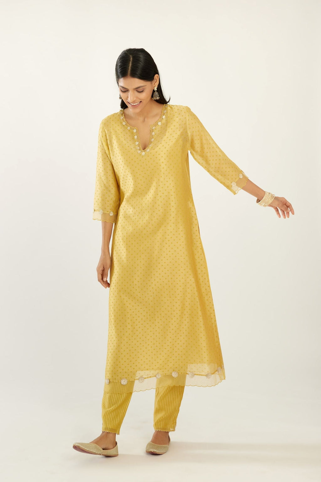 Yellow silk chanderi hand block printed straight kurta set, highlighted with organza and gota embroidered flower at edges.