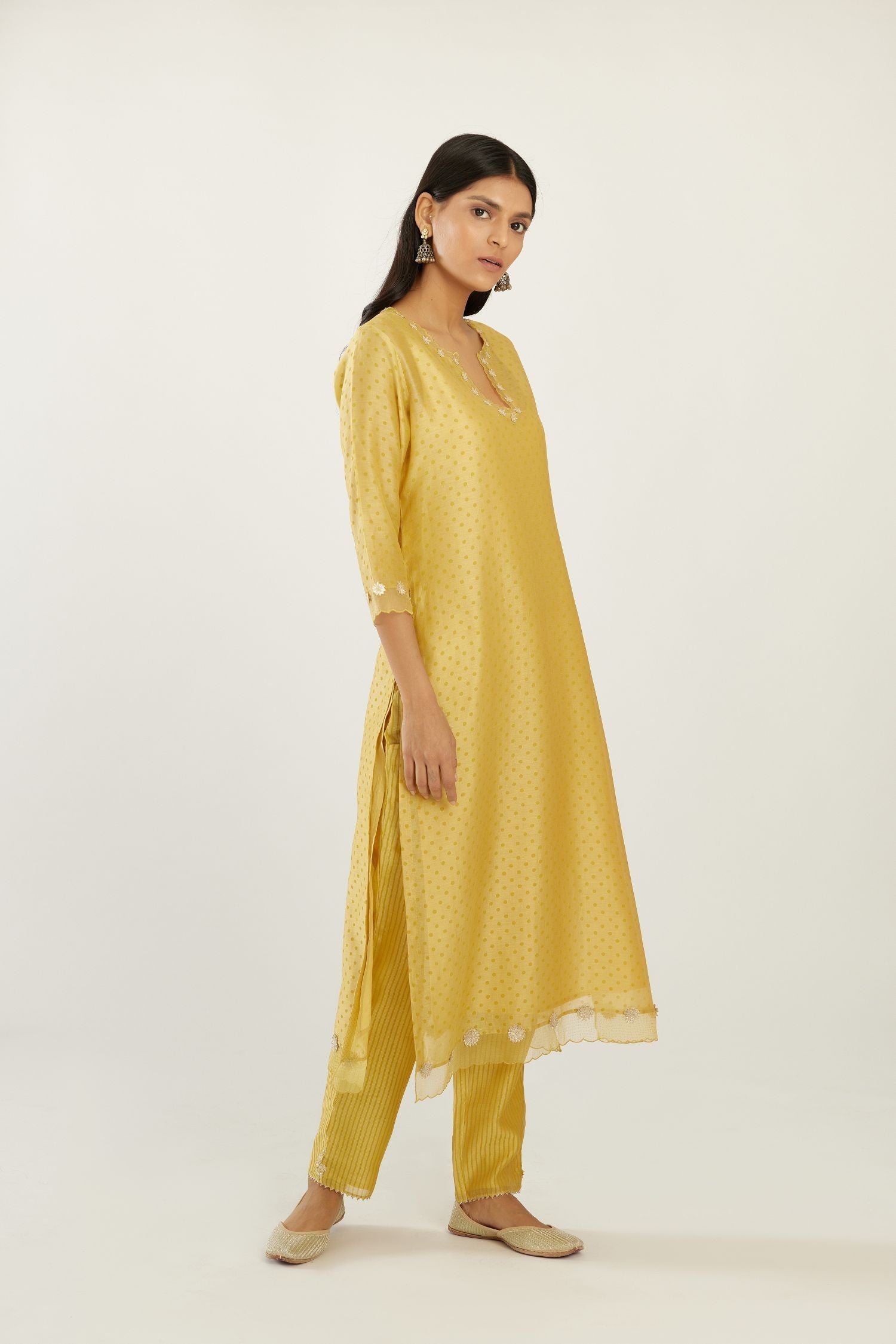 Yellow silk chanderi hand block printed straight kurta set, highlighted with organza and gota embroidered flower at edges.