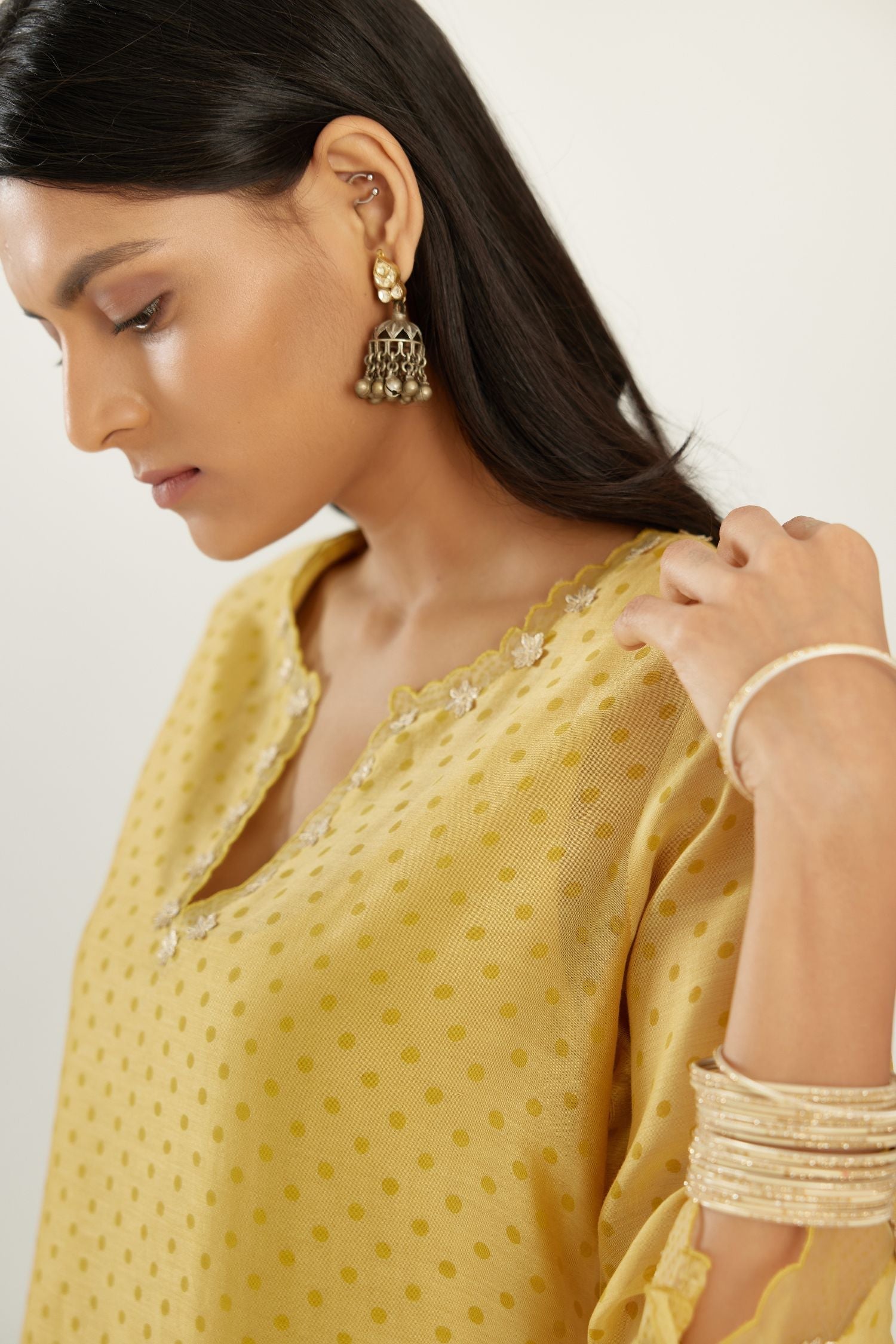 Yellow silk chanderi hand block printed straight kurta set, highlighted with organza and gota embroidered flower at edges.