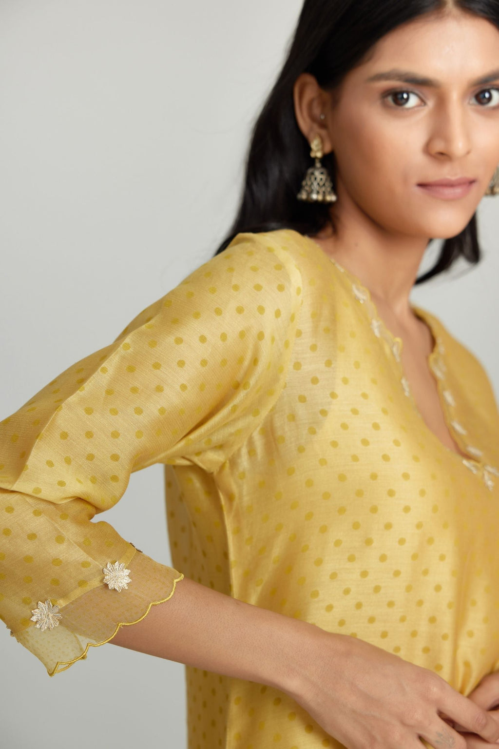 Yellow silk chanderi hand block printed straight kurta set, highlighted with organza and gota embroidered flower at edges.