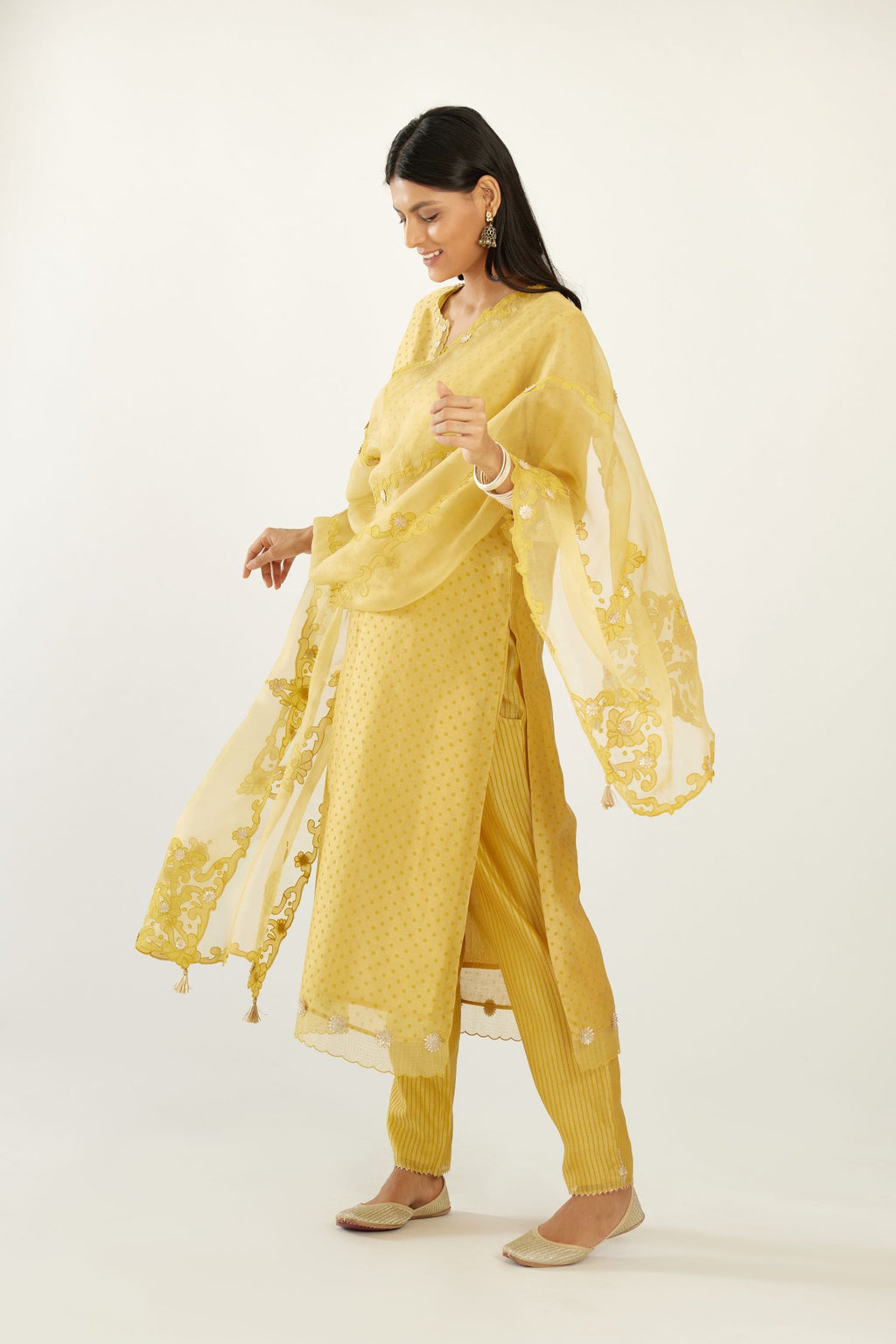 Yellow silk chanderi hand block printed straight kurta set, highlighted with organza and gota embroidered flower at edges.