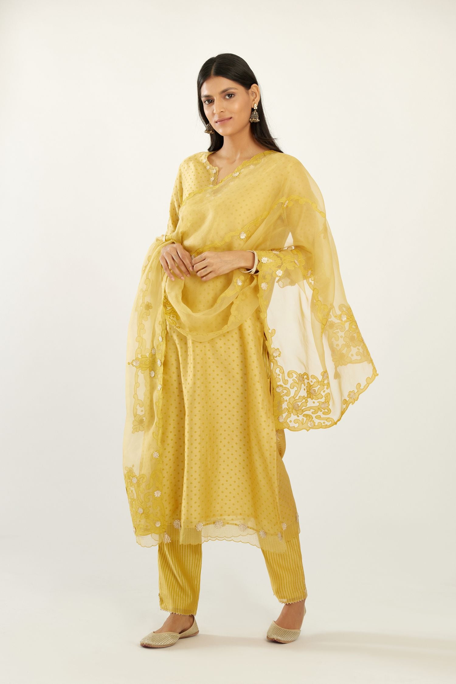 Yellow silk chanderi hand block printed straight kurta set, highlighted with organza and gota embroidered flower at edges.