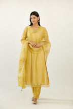 Yellow silk chanderi hand block printed straight kurta set, highlighted with organza and gota embroidered flower at edges.