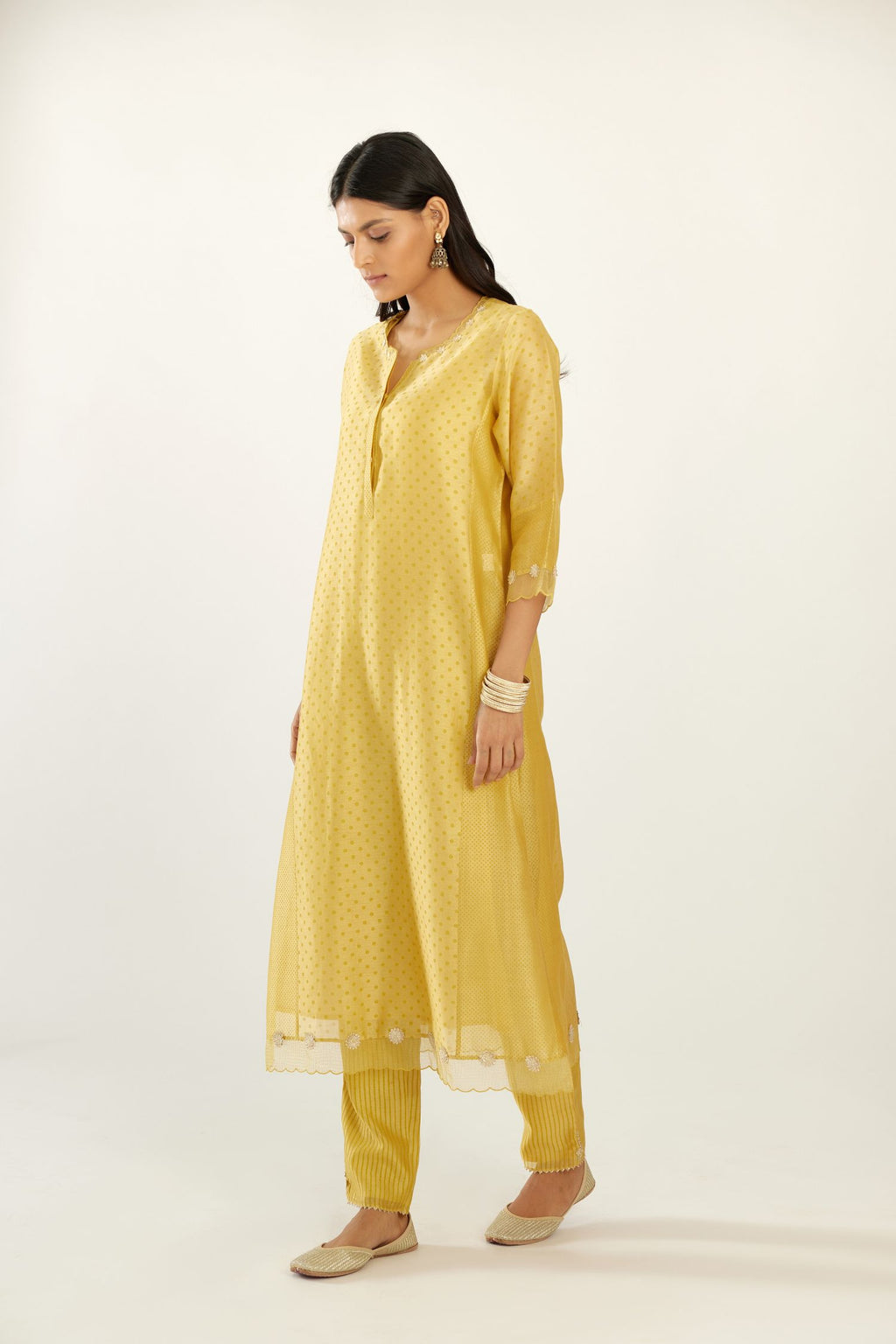 Yellow hand block printed silk chanderi kurta set with concealed button placket neckline, Highlighted with gota flower and scalloped organza at edges