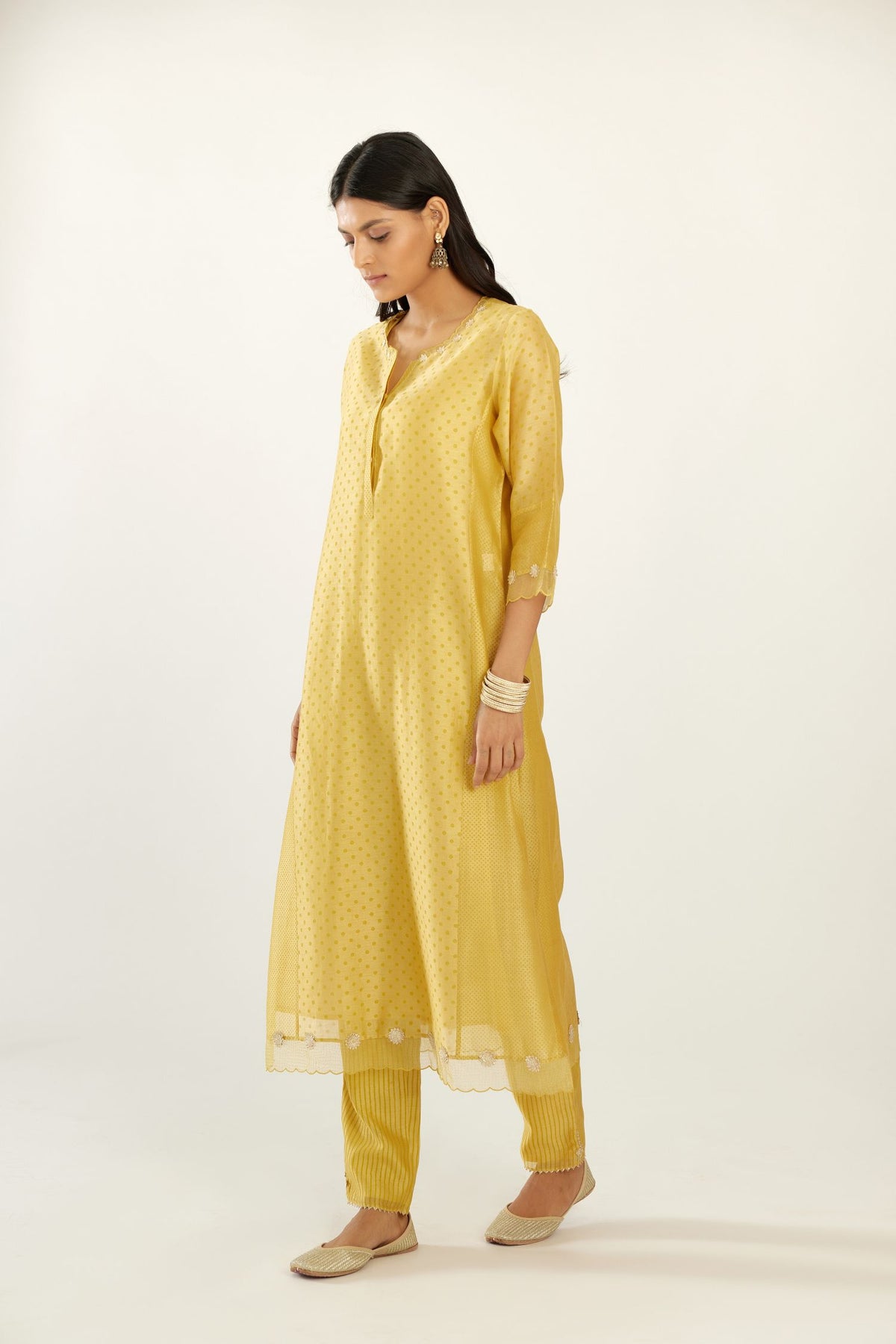 Yellow hand block printed silk chanderi kurta set with concealed button placket neckline, Highlighted with gota flower and scalloped organza at edges