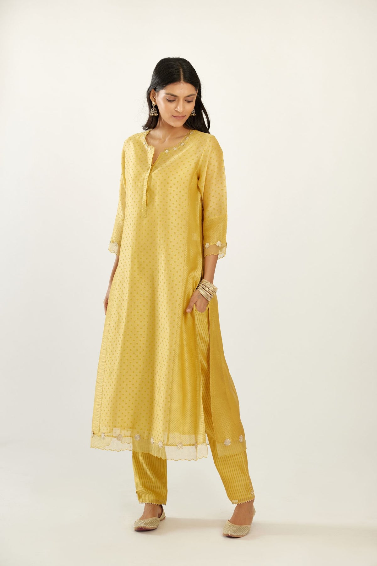 Yellow hand block printed silk chanderi kurta set with concealed button placket neckline, Highlighted with gota flower and scalloped organza at edges