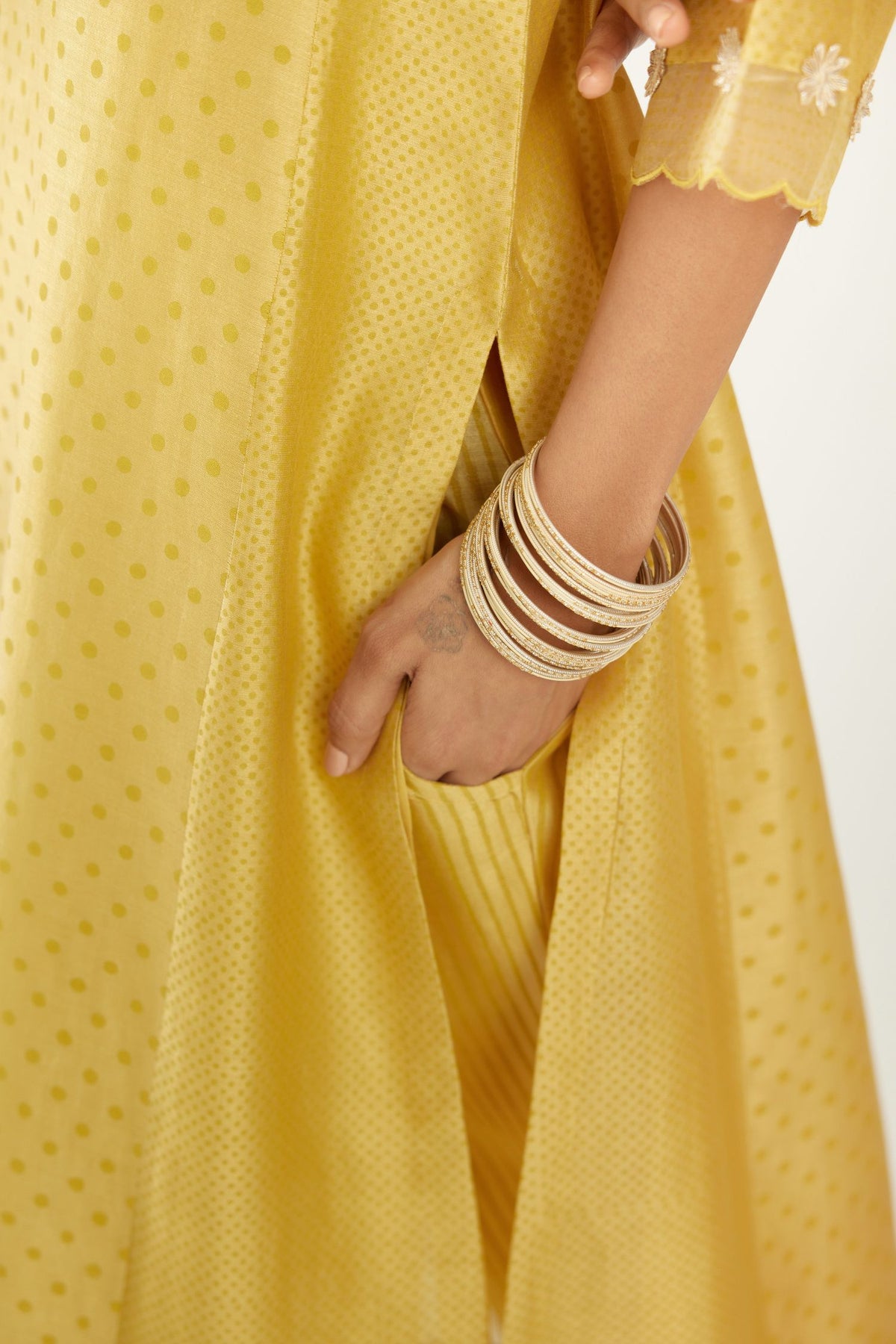 Yellow hand block printed silk chanderi kurta set with concealed button placket neckline, Highlighted with gota flower and scalloped organza at edges