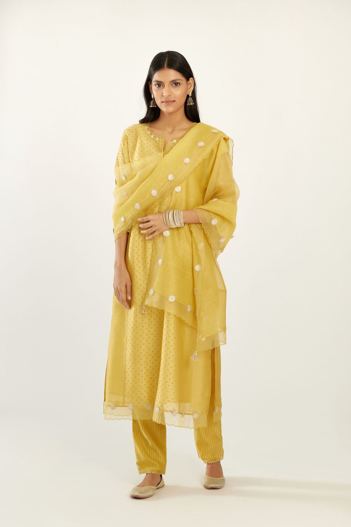 Yellow hand block printed silk chanderi kurta set with concealed button placket neckline, Highlighted with gota flower and scalloped organza at edges