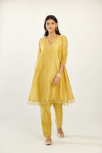 Yellow hand block printed silk chanderi easy fit short kurta set, highlighted with gota flower and scalloped organza at edges.