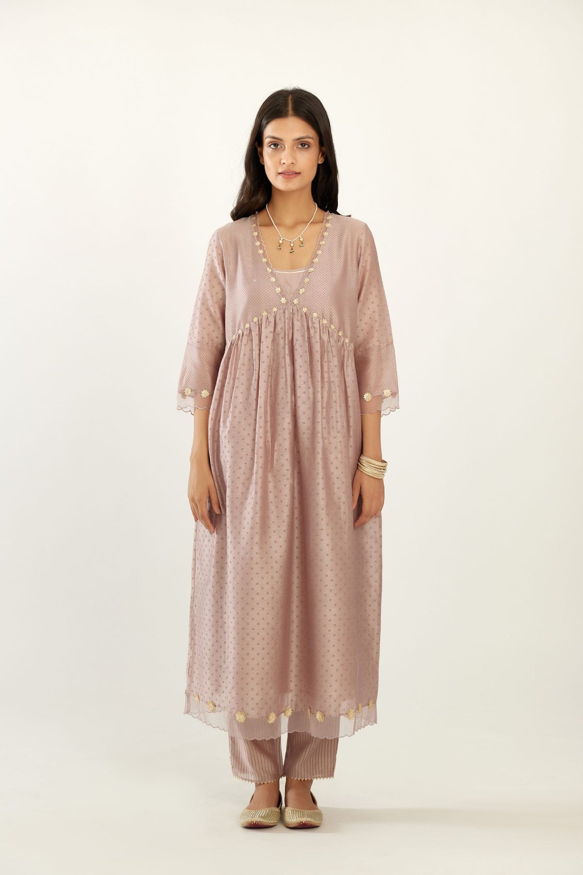 Lilac hand block printed V neck gathered kurta set, highlighted with gota flower embroidery and scalloped organza at edges.