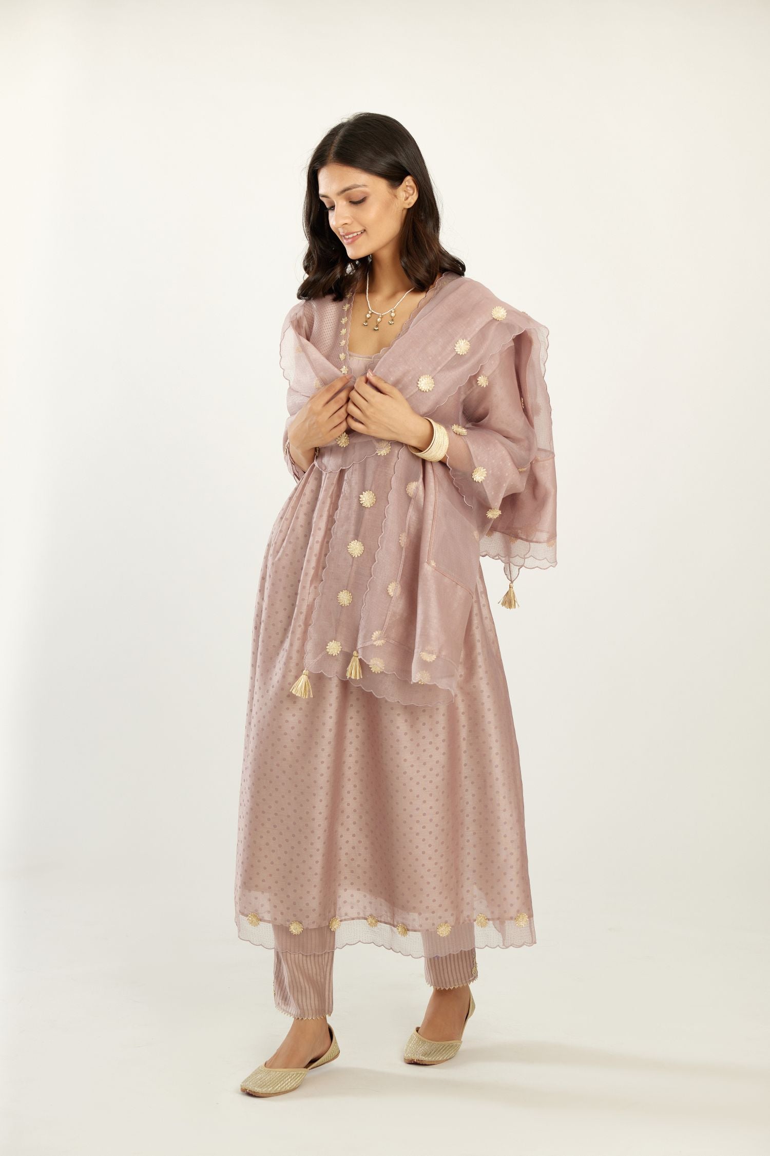Lilac hand block printed V neck gathered kurta set, highlighted with gota flower embroidery and scalloped organza at edges.