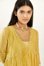 Yellow hand block printed V neck gathered kurta set, highlighted with gota flower embroidery and scalloped organza at edges.