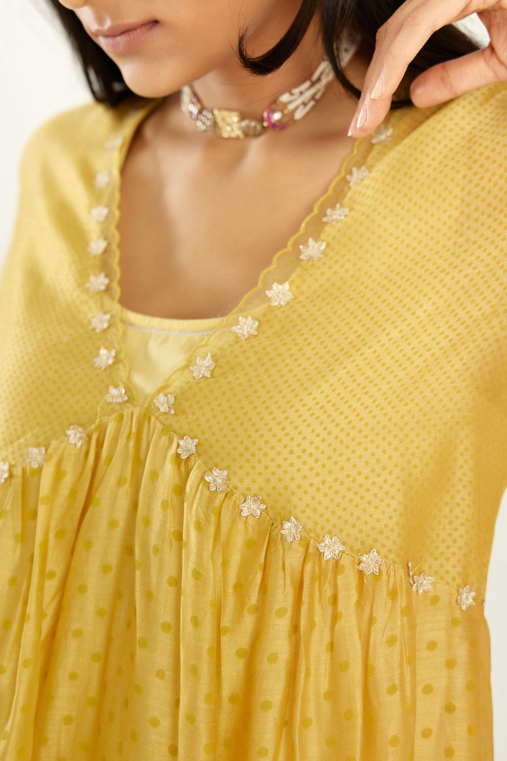 Yellow hand block printed V neck gathered kurta set, highlighted with gota flower embroidery and scalloped organza at edges.