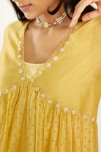 Yellow hand block printed V neck gathered kurta set, highlighted with gota flower embroidery and scalloped organza at edges.