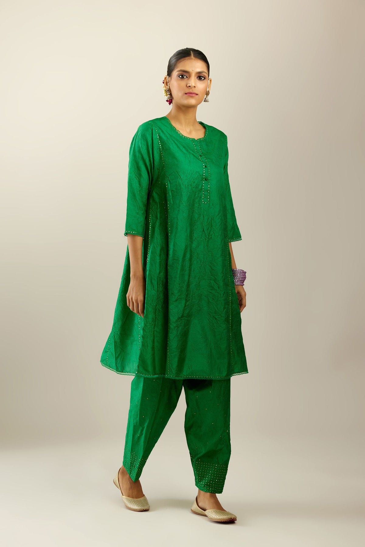 Silk hand crushed short kalidar kurta set with button placket, highlighted with gold sequins and embroidered scalloped organza at edges.