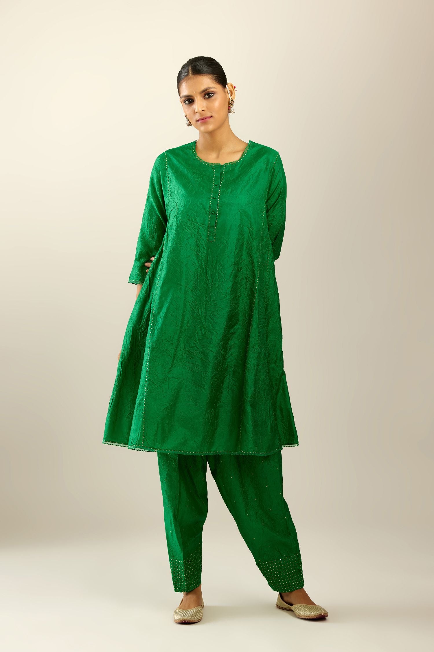 Silk hand crushed short kalidar kurta set with button placket, highlighted with gold sequins and embroidered scalloped organza at edges.
