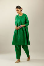 Silk hand crushed short kalidar kurta set with button placket, highlighted with gold sequins and embroidered scalloped organza at edges.