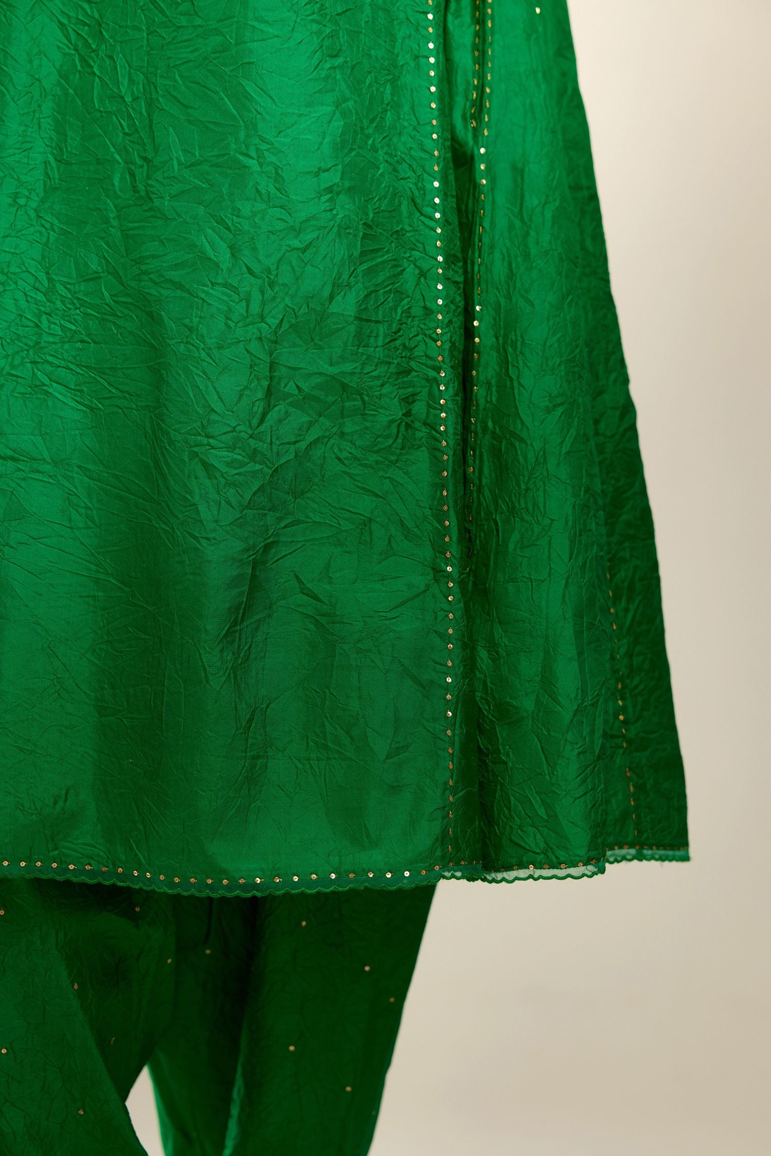 Silk hand crushed short kalidar kurta set with button placket, highlighted with gold sequins and embroidered scalloped organza at edges.