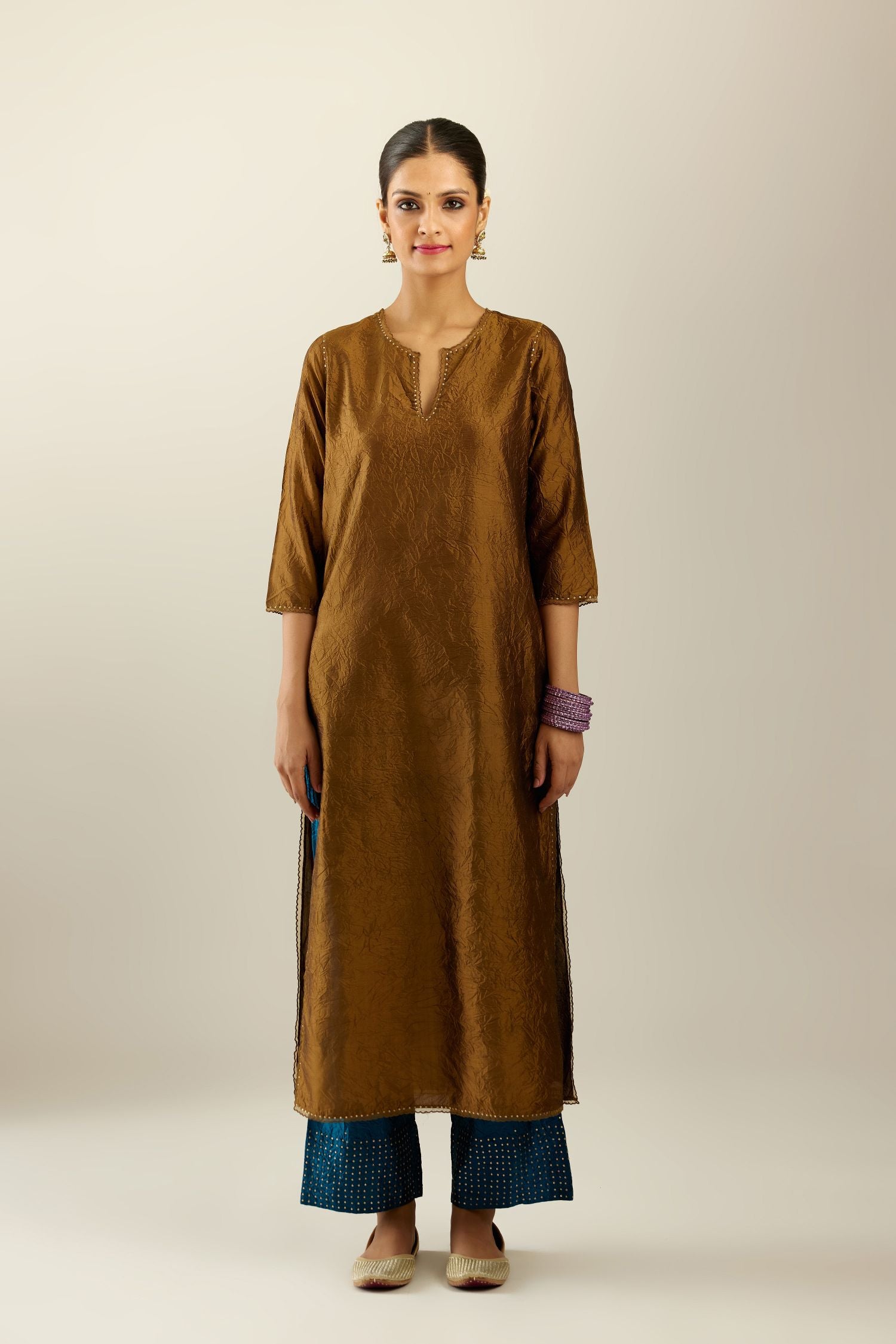 Golden olive silk straight kurta set, highlighted with organza and sequins at edges.