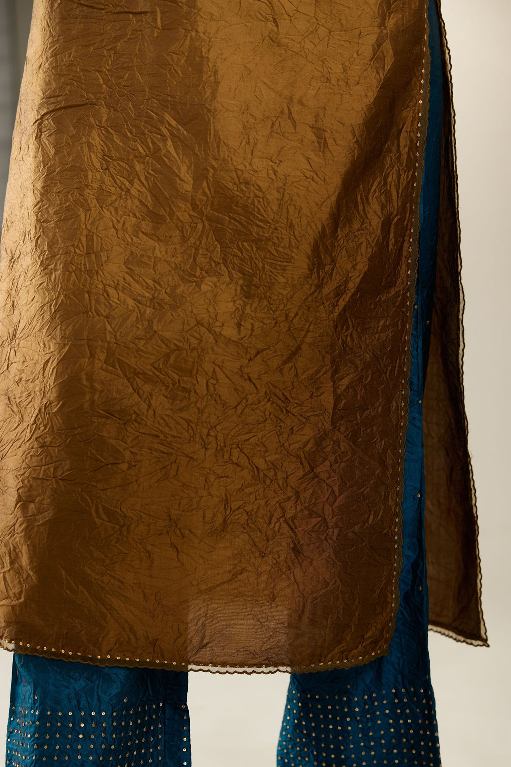 Golden olive silk straight kurta set, highlighted with organza and sequins at edges.