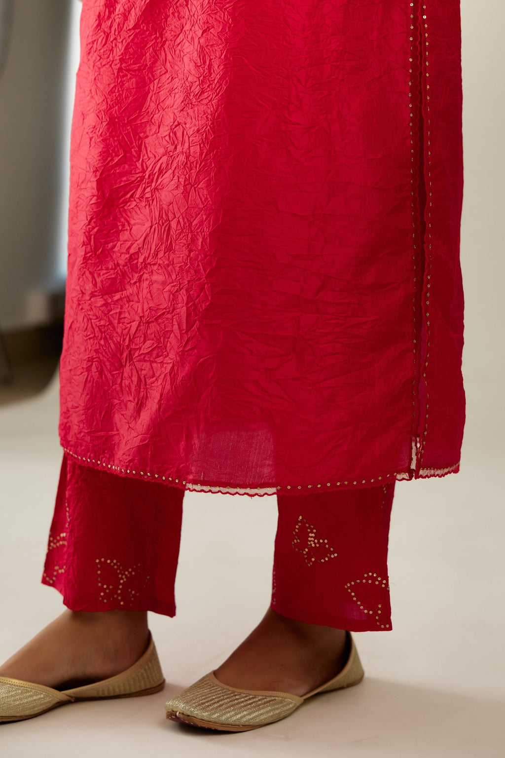 Red silk straight kurta set, highlighted with organza and sequins at edges.