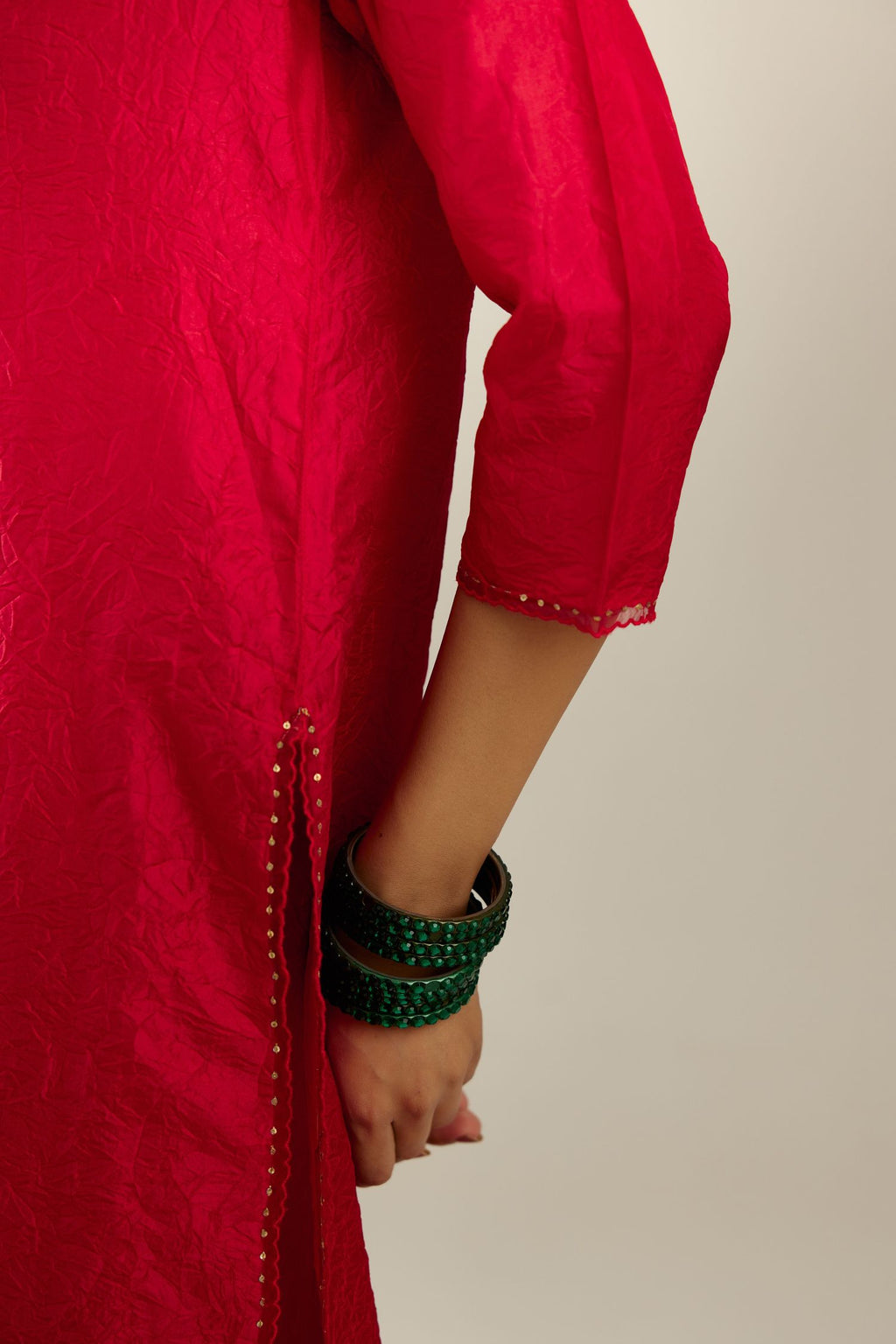 Red silk straight kurta set, highlighted with organza and sequins at edges.