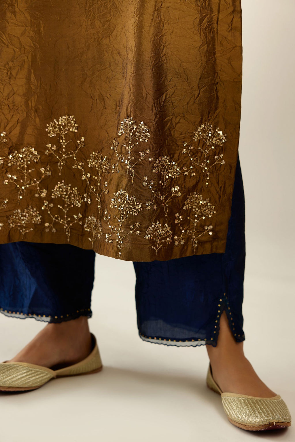 Golden olive hand crushed silk straight kurta set, highlighted with zari and sequins work at sleeve and hem.