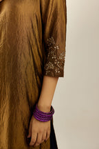 Golden olive hand crushed silk straight kurta set, highlighted with zari and sequins work at sleeve and hem.