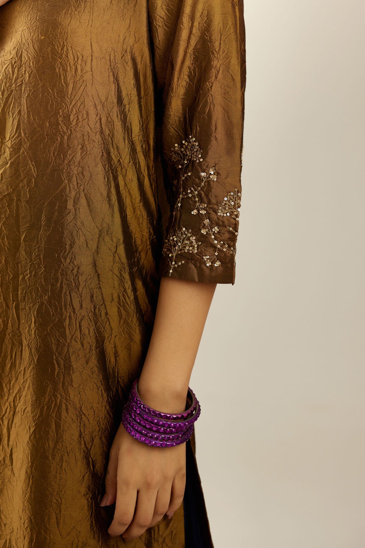 Golden olive hand crushed silk straight kurta set, highlighted with zari and sequins work at sleeve and hem.