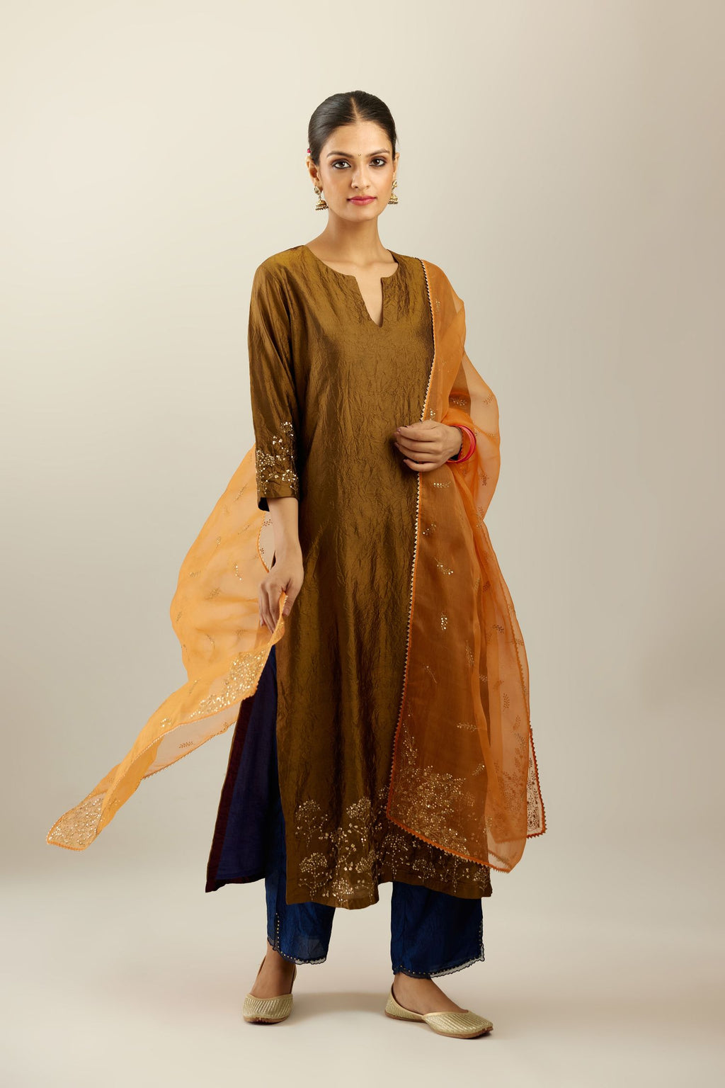 Orange silk organza dupatta with embroidered leaf clusters on all four corners of the dupatta and small leaf motif sprayed all over it.