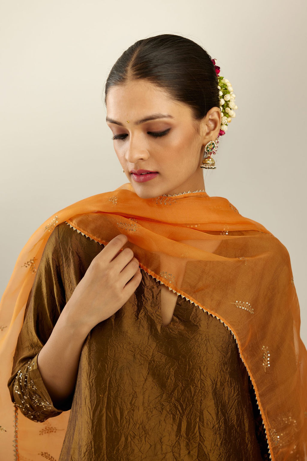 Orange silk organza dupatta with embroidered leaf clusters on all four corners of the dupatta and small leaf motif sprayed all over it.
