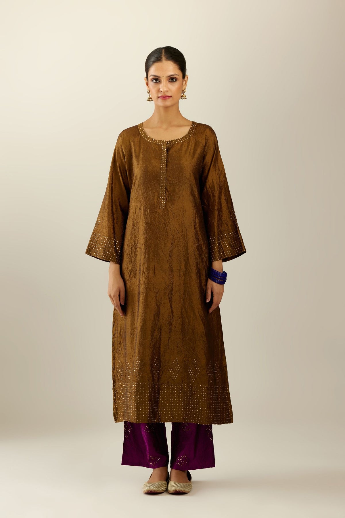 Golden olive silk hand crushed kurta set with concealed button placket neckline, highlighted with gold sequins heavy work at hem.
